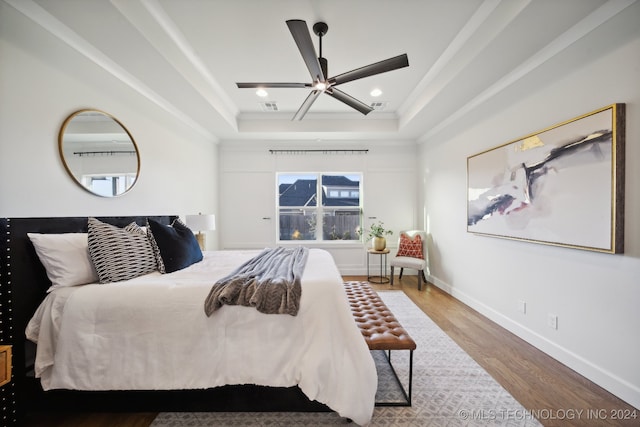 bedroom featuring a tray ceiling, ceiling fan, and hardwood / wood-style flooring