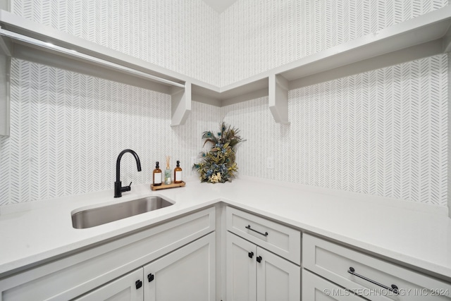 kitchen featuring white cabinetry and sink