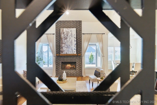 living room featuring hardwood / wood-style flooring and a brick fireplace