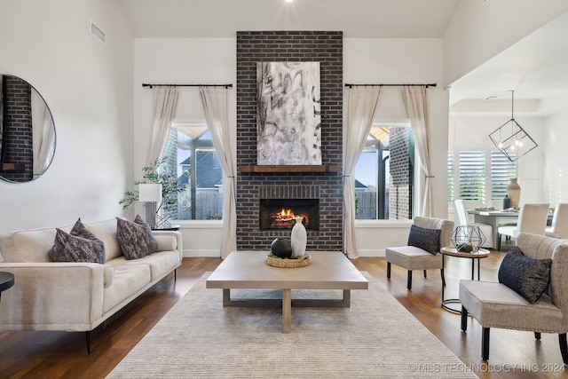 living room with a fireplace, a chandelier, and dark hardwood / wood-style floors