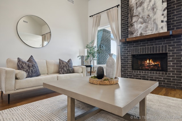 living room featuring hardwood / wood-style flooring and a large fireplace