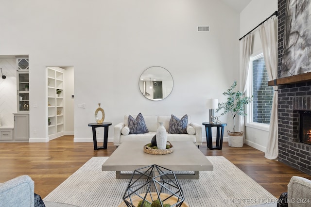 living room featuring a fireplace, dark wood-type flooring, and a healthy amount of sunlight