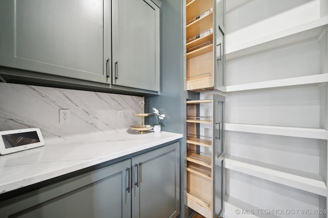 interior space with decorative backsplash and light stone countertops