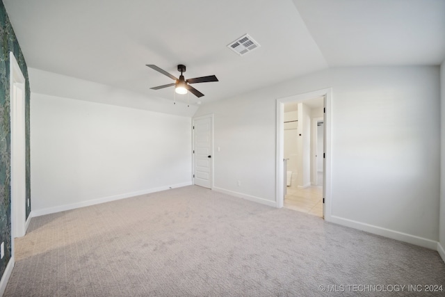 empty room featuring ceiling fan, light carpet, and lofted ceiling