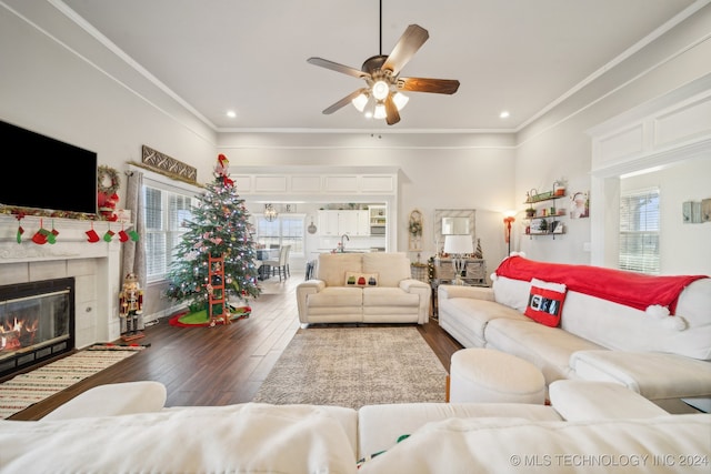 living room with a tile fireplace, ceiling fan, plenty of natural light, and dark hardwood / wood-style floors