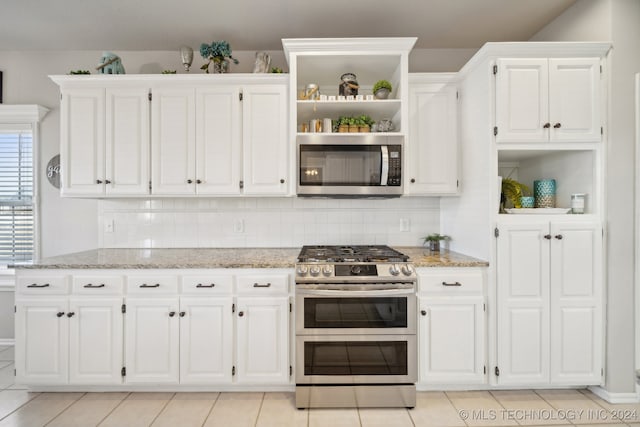 kitchen featuring decorative backsplash, light stone counters, white cabinetry, and stainless steel appliances