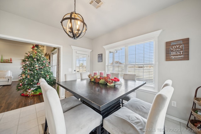 dining area with light wood-type flooring and a chandelier