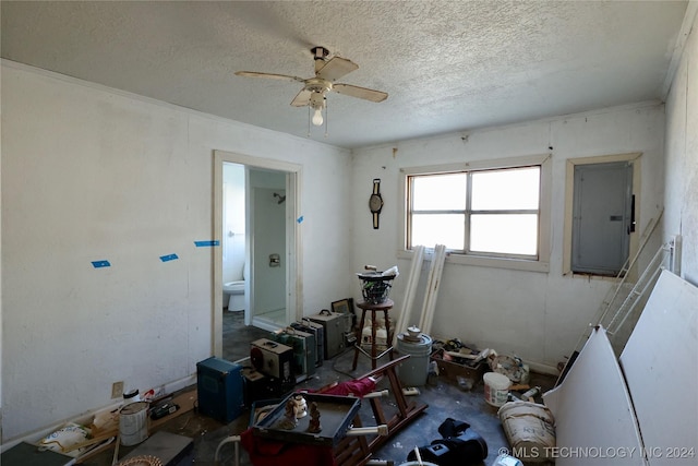 misc room with a textured ceiling, electric panel, and ceiling fan