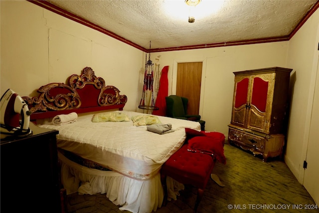 bedroom with dark hardwood / wood-style floors, ornamental molding, and a textured ceiling