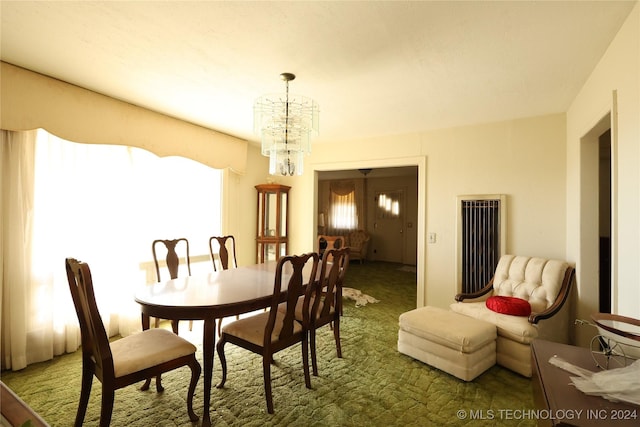 dining space with dark colored carpet and an inviting chandelier