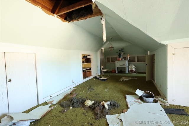 unfurnished living room featuring built in features and vaulted ceiling