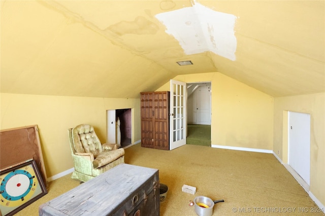 additional living space with carpet, french doors, and vaulted ceiling