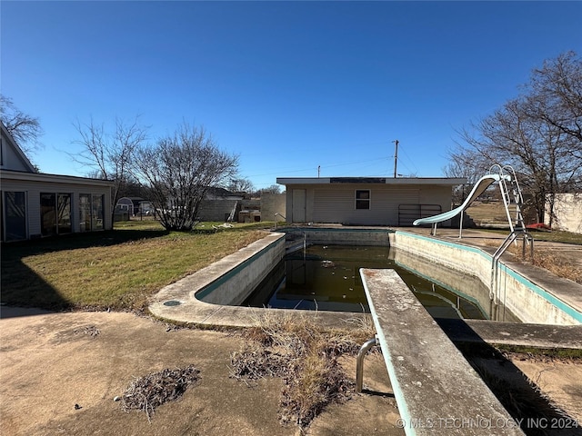 view of pool featuring a lawn and a water slide