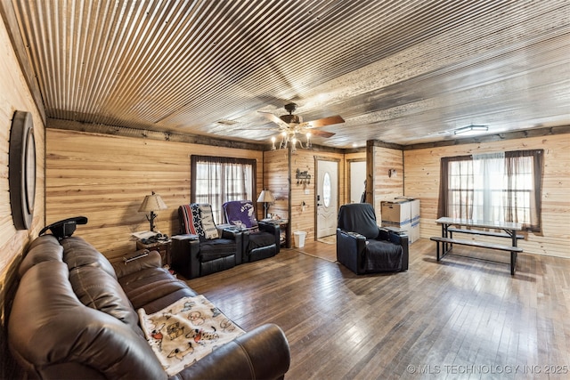 living room with wood walls, wood-type flooring, wooden ceiling, and a wealth of natural light