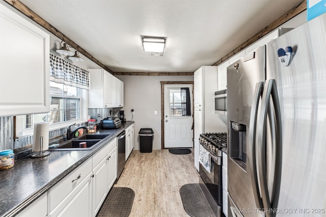 kitchen featuring sink, white cabinets, a textured ceiling, and appliances with stainless steel finishes