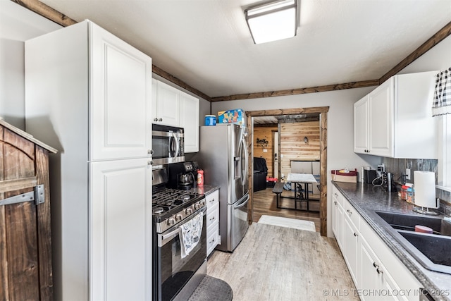 kitchen featuring sink, white cabinetry, stainless steel appliances, and light wood-type flooring