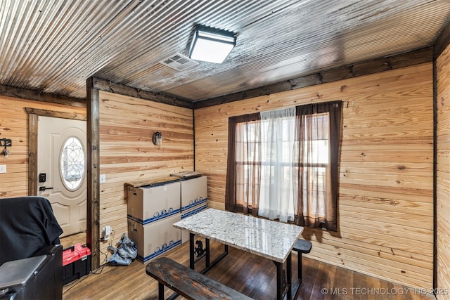 dining area featuring a wealth of natural light, wood walls, wooden ceiling, and hardwood / wood-style flooring