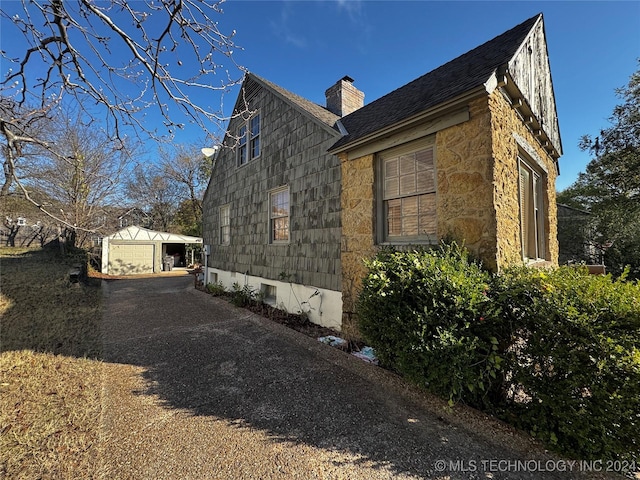 view of home's exterior featuring an outdoor structure and a garage