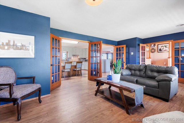 living room with light hardwood / wood-style floors and french doors