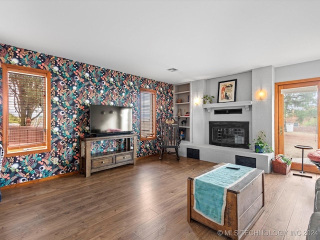 living room featuring a fireplace, hardwood / wood-style floors, and built in features