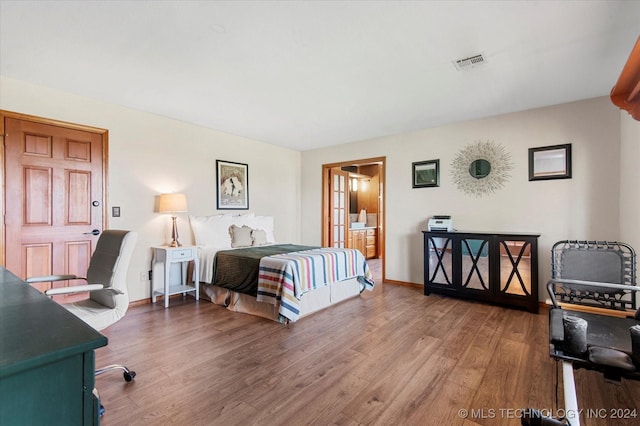 bedroom featuring hardwood / wood-style floors and connected bathroom