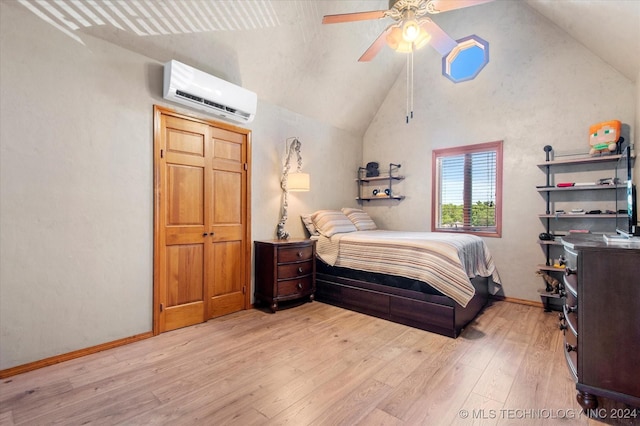 bedroom with a wall mounted air conditioner, light wood-type flooring, high vaulted ceiling, and ceiling fan