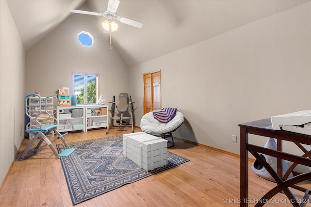 living area with ceiling fan, hardwood / wood-style floors, and high vaulted ceiling