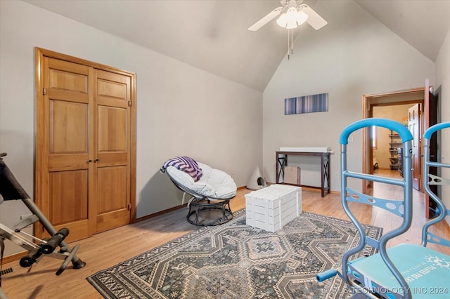 living area featuring ceiling fan, light wood-type flooring, and high vaulted ceiling