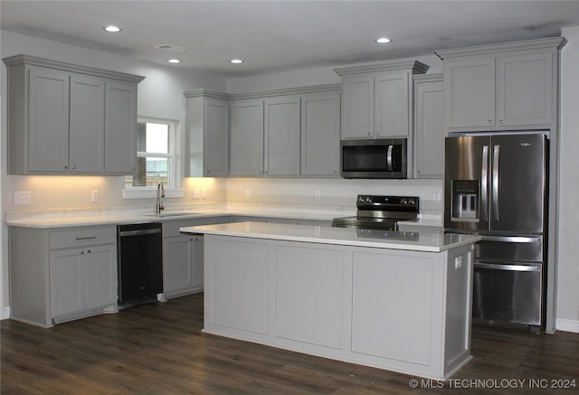 kitchen with appliances with stainless steel finishes, dark hardwood / wood-style floors, gray cabinetry, and sink