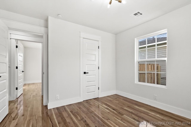 unfurnished bedroom featuring wood-type flooring and a closet