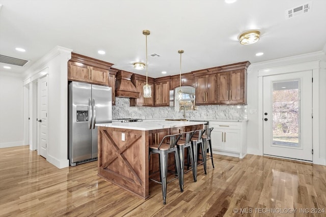 kitchen with white cabinetry, stainless steel fridge with ice dispenser, light hardwood / wood-style flooring, decorative light fixtures, and custom range hood