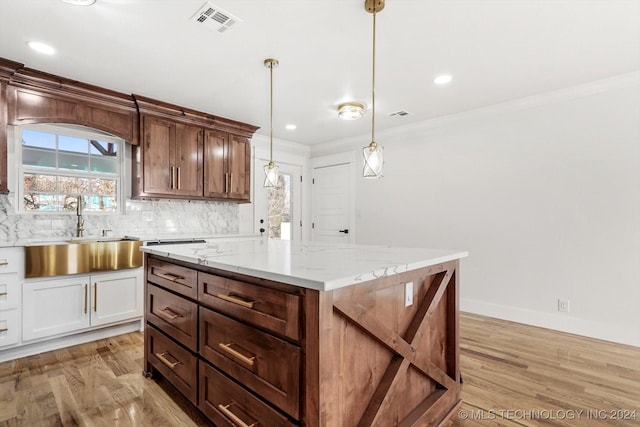 kitchen with a center island, white cabinetry, light hardwood / wood-style flooring, and sink