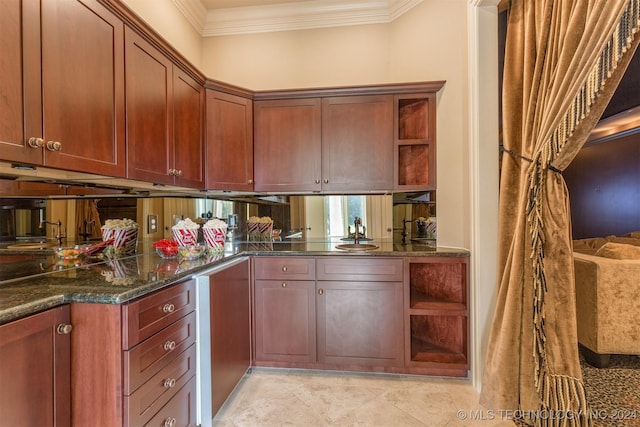 kitchen featuring crown molding, sink, and dark stone counters