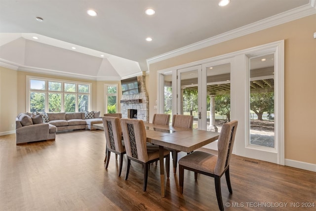 dining space with a fireplace, hardwood / wood-style floors, and ornamental molding