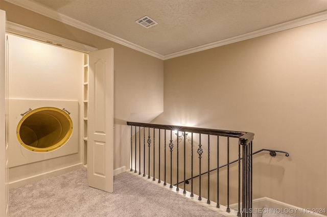 washroom featuring a textured ceiling, light colored carpet, and crown molding