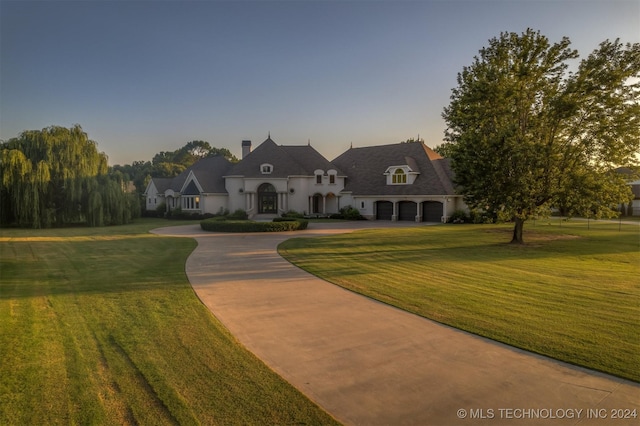 3520 W 77th St S, Tulsa, OK 74132 - french country home featuring curved driveway, a yard, and a chimney