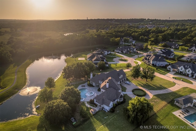 aerial view at dusk featuring a water view