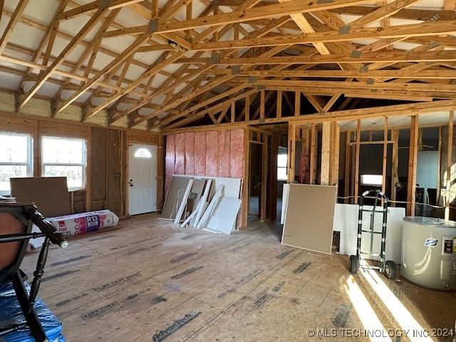 misc room with water heater and vaulted ceiling