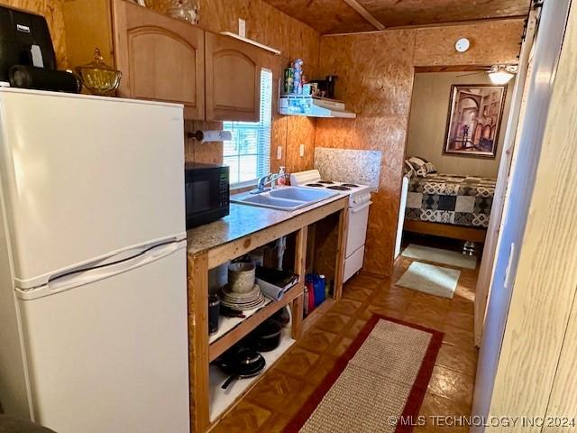 kitchen featuring ventilation hood, white appliances, and sink