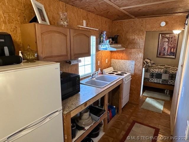 kitchen featuring sink, white appliances, wooden walls, and range hood