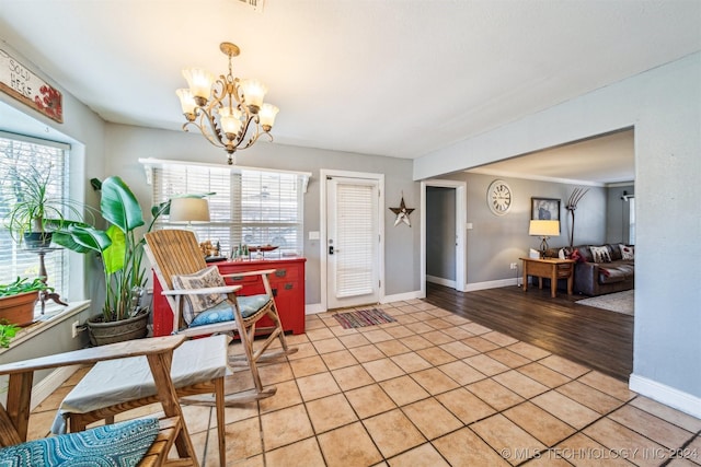 dining area featuring light wood-type flooring, an inviting chandelier, and plenty of natural light