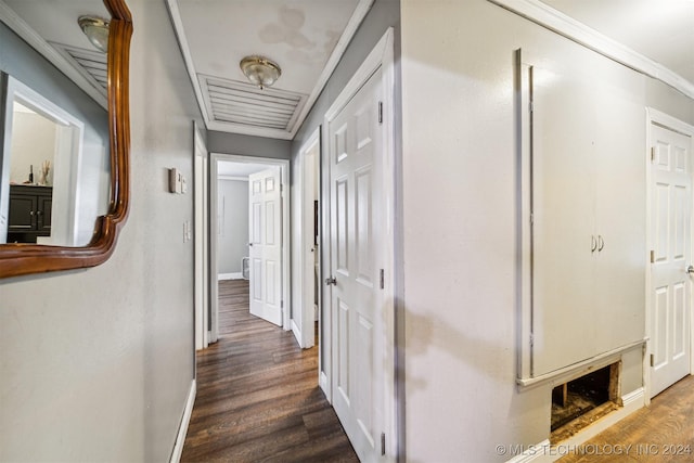 hall with ornamental molding and dark wood-type flooring