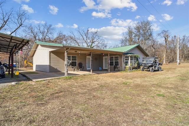 back of property with a yard and a patio