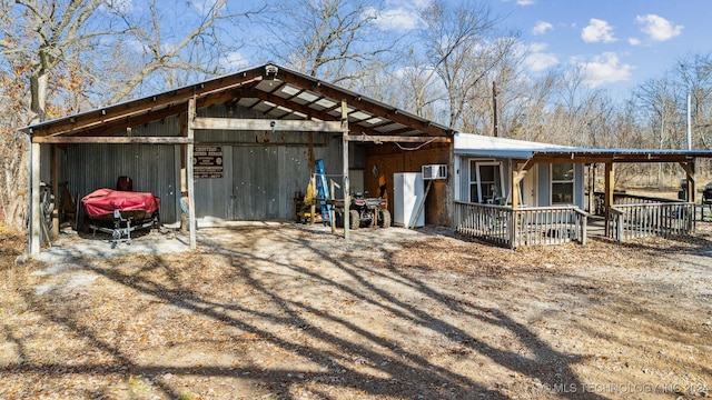 view of front facade featuring a wall mounted air conditioner and an outbuilding