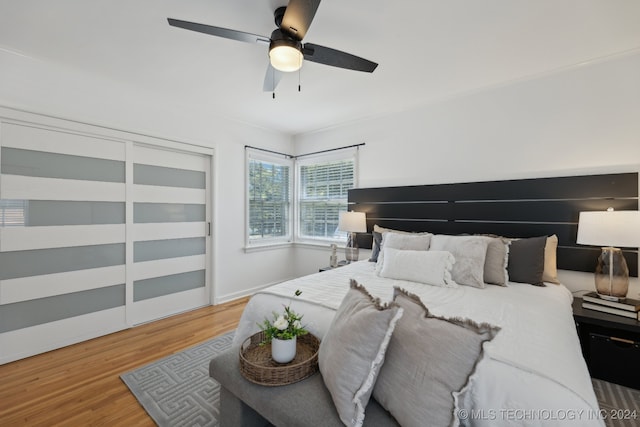 bedroom featuring wood-type flooring, a closet, and ceiling fan