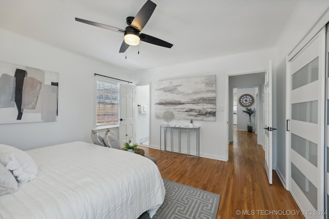 bedroom with dark hardwood / wood-style floors, ceiling fan, and ornamental molding