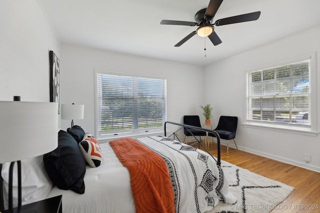 bedroom with ceiling fan, wood-type flooring, and crown molding