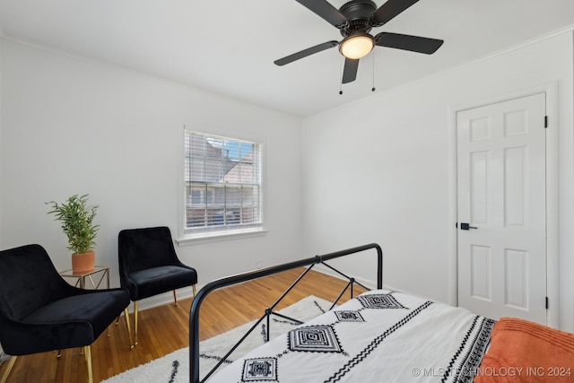 bedroom with wood-type flooring, ceiling fan, and ornamental molding