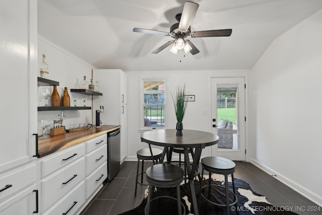 tiled dining room with vaulted ceiling, bar, and ceiling fan