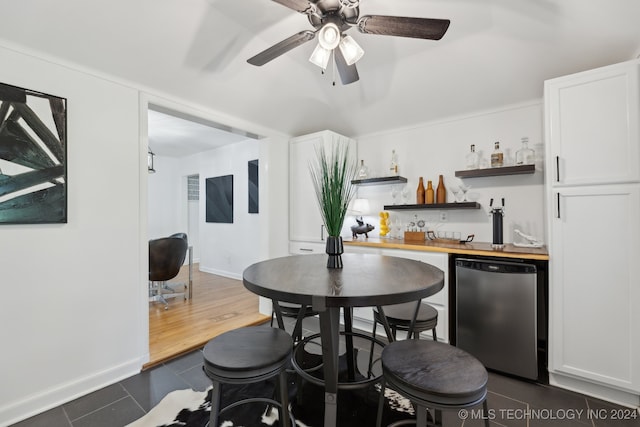 dining area featuring ceiling fan, dark hardwood / wood-style floors, and indoor bar